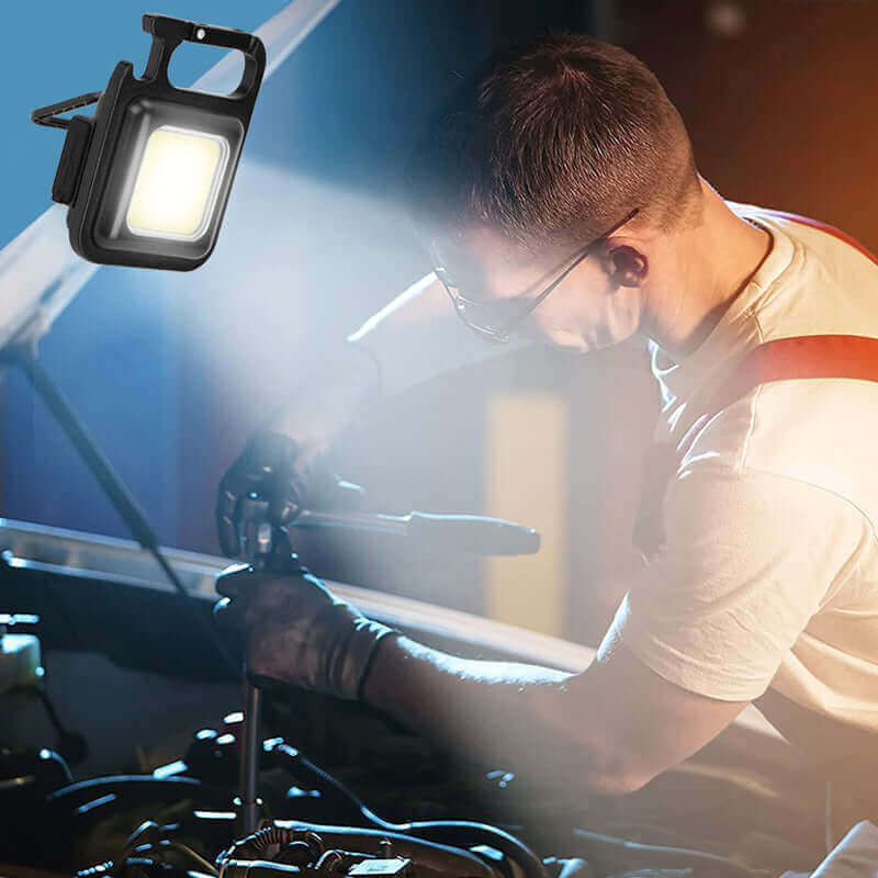 Mechanic using Mini Waterproof Pocket Torch LED Keychain Flashlight for lighting engine compartment while performing car repair